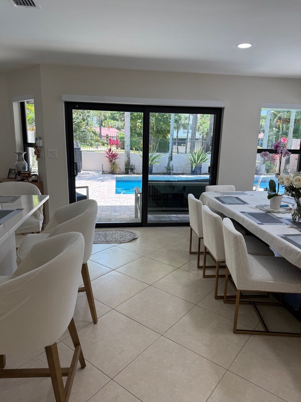 Bright dining area with white chairs in a home cleaned by Cleanantsy
