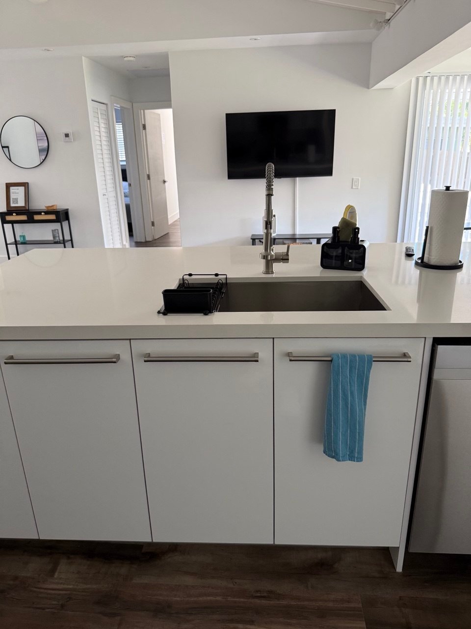 White kitchen island and sink in a home cleaned by Cleanantsy